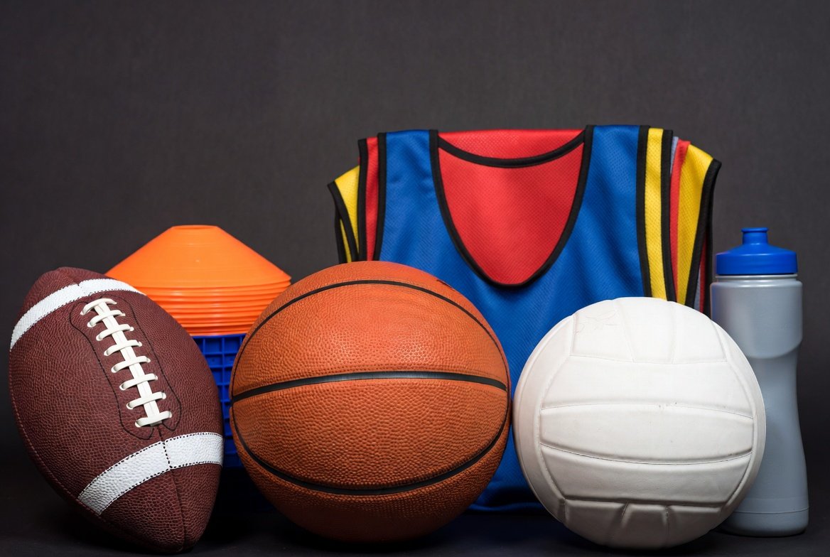 Team sports gear including footballs and basketballs